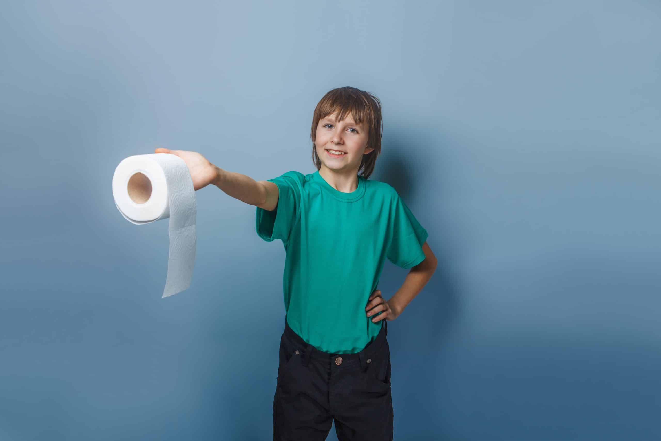 Child holding out a roll of toilet paper